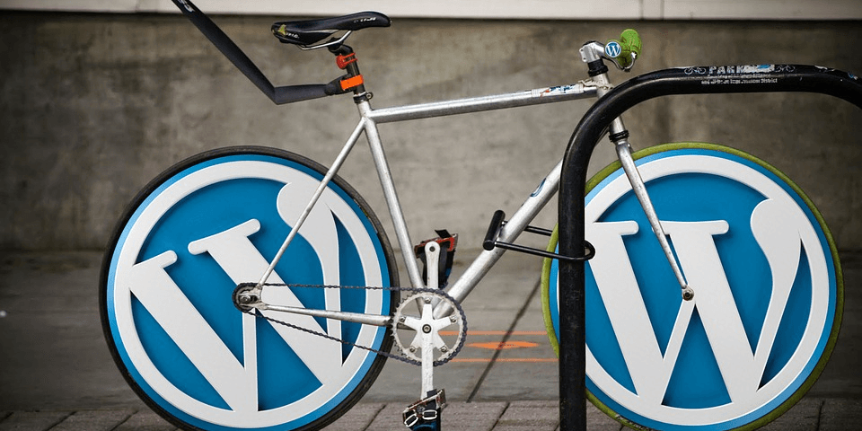 Bicycle with pairs of wordpress logo placed on wheels.